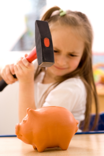 Girl about to smash a piggy bank with a hammer